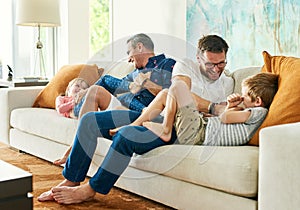 Gay parents, family fun and living room with dads and kids together with laugh and tickle. Parent love, bonding and care