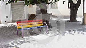 Gay pride rainbow colors painted bench on the street