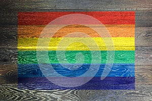 Gay pride rainbow flag on rustic old wood surface background