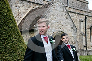 Gay wedding, grooms leave village church after being married with big smiles and holding hands