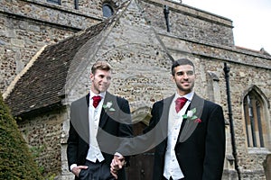 Gay wedding, grooms leave village church after being married with big smiles and holding hands