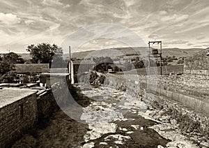 Gayle Beck, flowing through the village, with stone buildings and hills in, Gayle, Hawes, UK