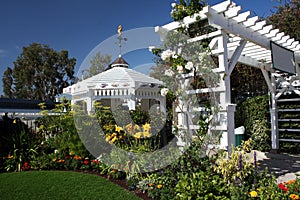 Gazebo and arch in lush garden photo