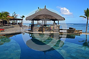 Gazebo bar next to a pool at tropical beach of a hotel resort