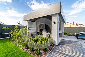 Gazebo with built-in barbecue. Table and chairs. Great design. Green lawn around