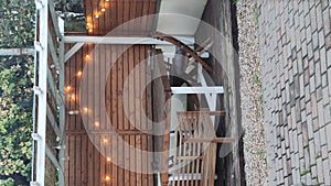 Gazebo with lights at night. Picture of a summer house with comfortable garden furniture. Romantic scene in dusk