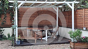 Gazebo with lights at night. Picture of a summer house with comfortable garden furniture. Romantic scene in dusk