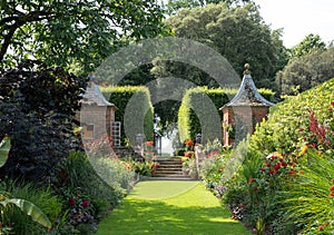 Gazebos at the end of the Red Border in the Arts and Crafts inspired garden at Hidcote Manor in the Cotswolds, Gloucestershire UK