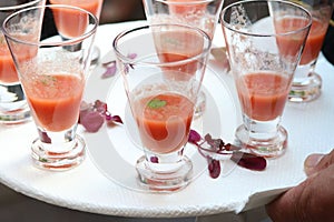 Gazpacho soup appetizers in glasses on white platter