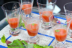 Gazpacho soup in glasses on blue and white tablecloth