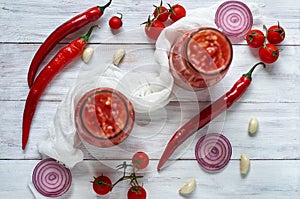 Gazpacho soup ingredients - three hot red chili peppers, onion rings, garlic and small cherry tomatoes decorated with white cloth