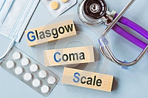 GCS Glasgow Coma Scale text, written on wooden blocks with stethoscope on blue background