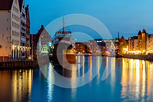 Gdansk night city riverside view with moored ship. View on famous facades of old medieval houses