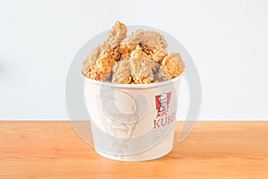 A lots of KFC chicken hot wings in bucket of KFC Kentucky Fried Chicken fast food.