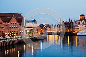 Polish Baltic Philharmonic and old town buildings with river at night in Gdansk, Poland