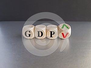 GDP, gross domestic product symbol. Businessman holds a cube with up and down icon. Word \'GDP\'.
