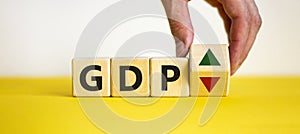 GDP, gross domestic product symbol. Businessman holds a cube with up and down icon. Word `GDP`. Beautiful white background. Copy