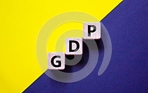 GDP, gross domestic product symbol. Concept words `GDP, gross domestic product` on cubes on a beautiful yellow and black