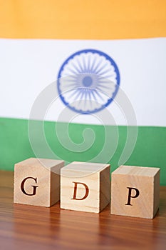 GDP or gross domestic product in wooden block letters, Indian Flag as a background