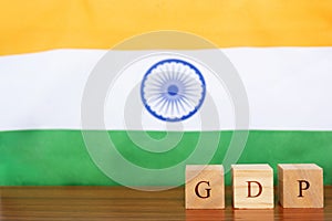 GDP or gross domestic product in wooden block letters, Indian Flag as a background