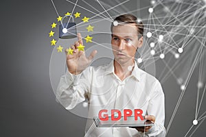 GDPR concept. General Data Protection Regulation, the protection of personal data. Young man with tablet works with a