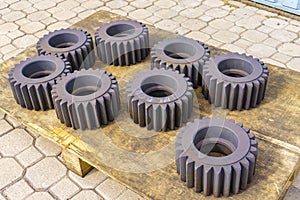 Gear after heat treatment and hardening on a wooden rack, improving the hardness of the metal