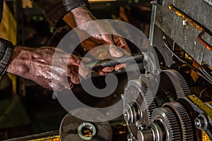 Gear metal wheels with worker hands in industrial machine close-up