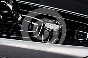 Gear shift controller in new luxurious car interior near automatic gearbox handle close up view.