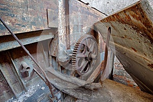 The gear wheel of a rusty old machine in brick factory