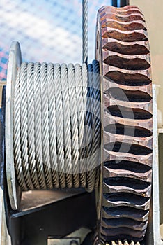 Gear wheel and steel rope. Detail of a crane or steel structure tension.