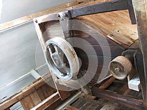 Gears and pulleys in an old wooden watermill used for grinding f