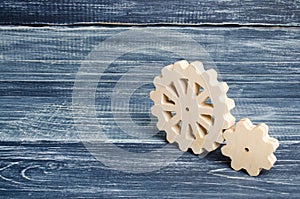 Gears of wood stand on a dark wooden background. Concept of technology and industry, engineering. Mechanical parts, technological