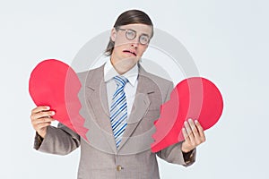 Geeky businessman crying and holding broken heart card