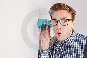 Geeky businessman eavesdropping with cup