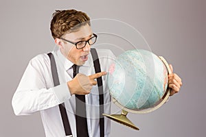 Geeky businessman pointing to globe