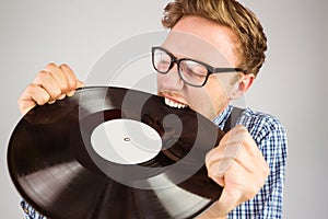Geeky hipster biting vinyl record