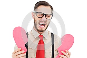 Geeky hipster crying and holding broken heart card