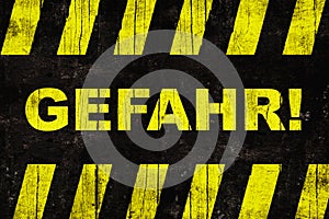 Gefahr in German, â€œdangerâ€ text warning sign with yellow and black stripes