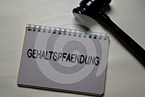 Gehaltspfaendung write on a book with gavel isolated on Office Desk. German Language it means Salary Garnishment