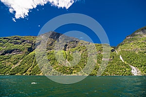 Geiranger, Norway - June, 2019: Hurtigruten cruise liner sailing on the Geirangerfjord, one of the most popular destination in