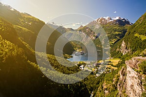 Geiranger village and ferry surrounded by mountains in sunny weather, Sunnmore, Romsdal, Norway