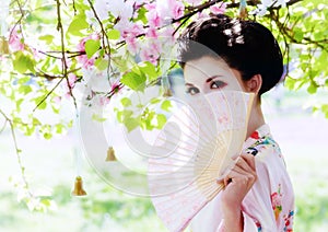 Geisha with fan in the garden