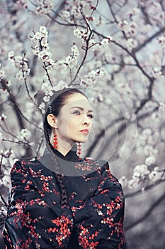 Geisha in red kimono in sakura