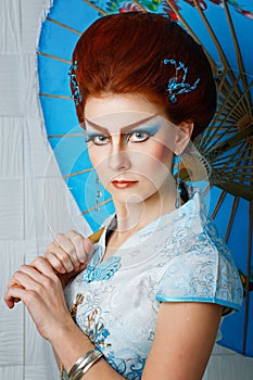 Geisha in a smart dress with umbrella