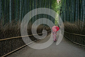 Geisha with umbrella in Arashiyama bamboo forest
