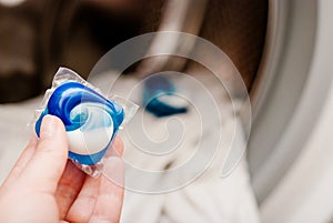 Gel capsule in hand for washing mashine, liquid coloured detergent