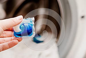 Gel capsule in hand for washing mashine, liquid coloured detergent