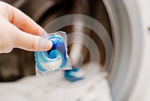 Gel capsule in hand for washing mashine, liquid coloured detergent