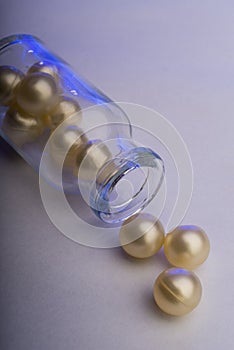 Gel capsules in a bottle illuminated with blue lighting