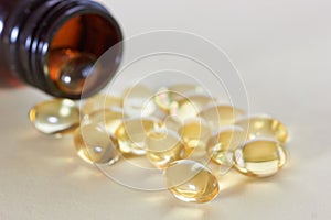 Gel capsules. pills spilling out of prescription bottle on table
